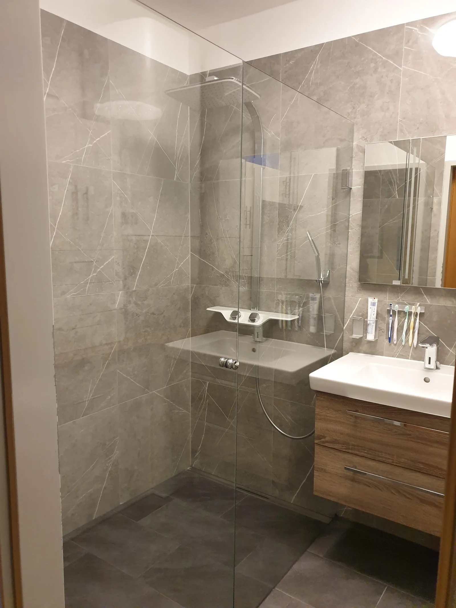 Badezimmer mit bodengleicher Dusche und Glaswand